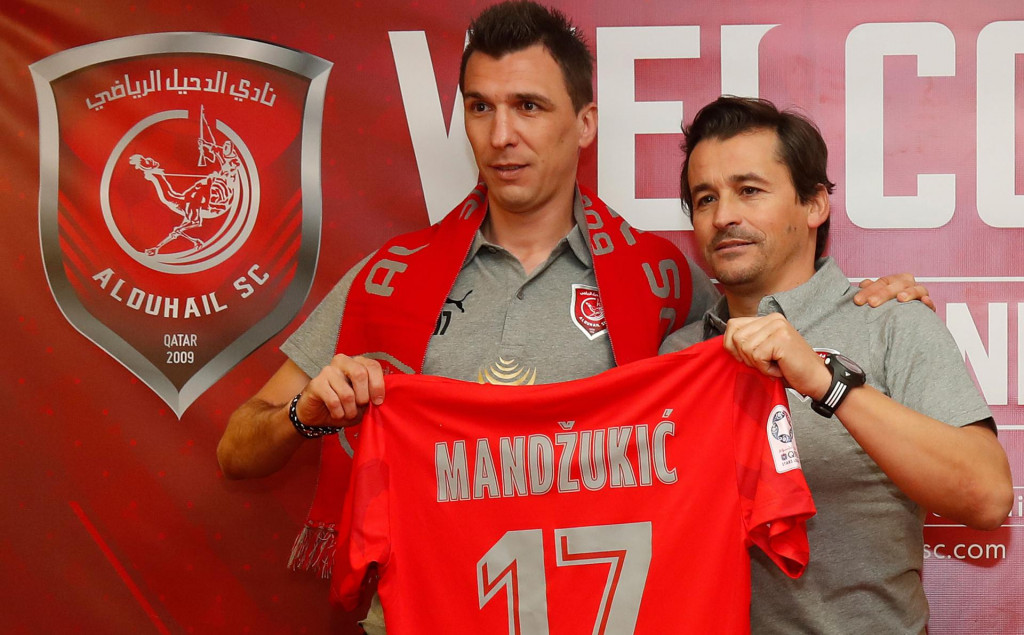 Croatian forward Mario Mandzukic (L) is presented with the number 17 jersey by coach Rui Faria during his introduction as a new player for Qatar&amp;#39;s Al Duhail football team on January 2, 2020, in the Qatari capital Doha. - Mandzukic had previously played for Germany&amp;#39;s Bayern Munich, Spain&amp;#39;s Atletico Madrid and Italy&amp;#39;s Juventus before signing for the Qatar club. (Photo by KARIM JAAFAR/AFP)
