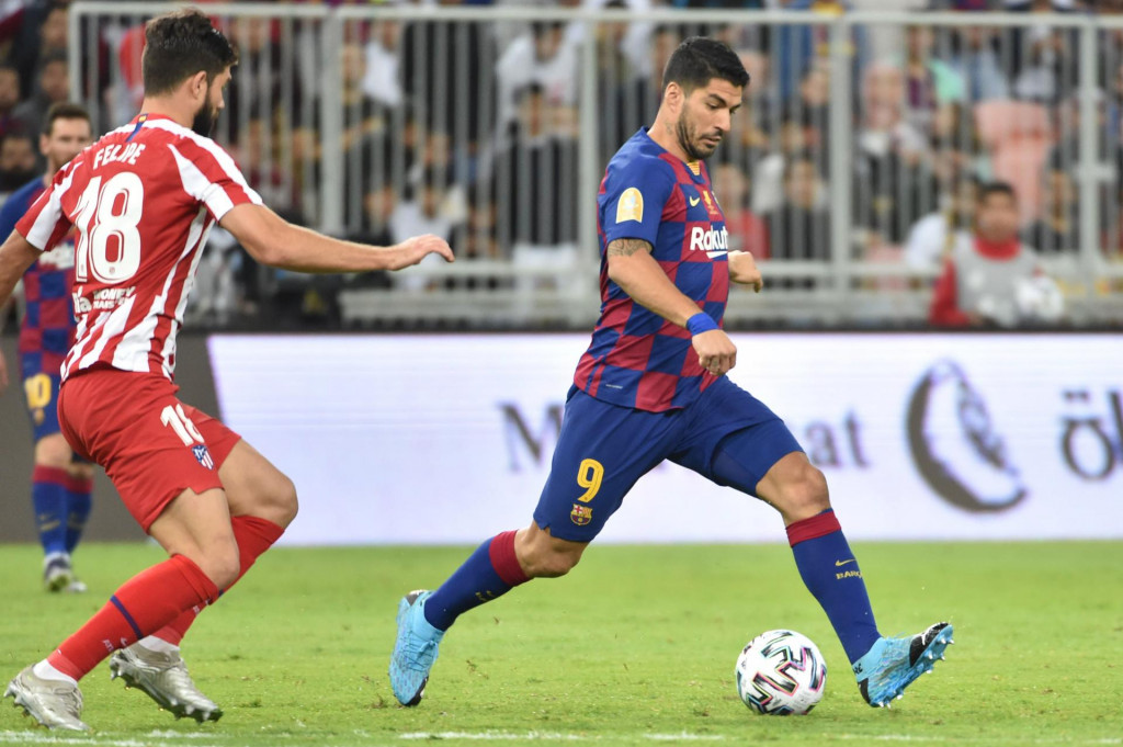 Barcelona&amp;#39;s Uruguayan forward Luis Suarez (R) passes the ball during the Spanish Super Cup semi final between Barcelona and Atletico Madrid on January 9, 2020, at the King Abdullah Sport City in the Saudi Arabian port city of Jeddah. - The winner will face Real Madrid in the final on January 12. (Photo by FAYEZ NURELDINE/AFP)