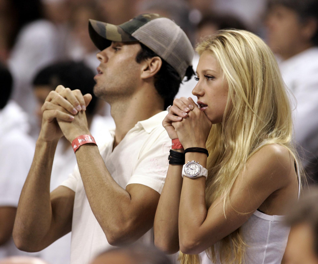 Former tennis player Anna Kournikova (R) of Russia and boyfriend Enrique Iglesias (L) of Spain watches during Game 3 of the NBA finals between the Miami Heat and the Dallas Mavericks at American Airlines Arena in Miami 13 June 2006. The Heat with 42 points in the 98-96 win but still trail the best-of-seven game series 2-1. AFP PHOTO/Jeff HAYNES (Photo by JEFF HAYNES/AFP)