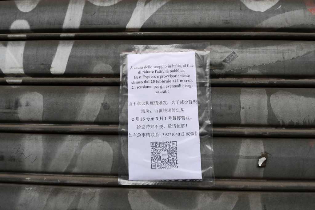 A picture shows a board reading ”As a consequence of the current health situaion, our stablishment has decided to suspend its activity from February 25 until March 1”, on an iron curtain of a shop in the Chinese district of Milan on February 25, 2020. - The decision to close the stores was made by the Chinese community of the city of Milan as a consequence of the current health situation, following the outbreak of the new coronavirus. Several towns in northern Italy have been put under isolation measures in an attempt to stem the spread of the virus. Seven people in Italy have so far died after catching the virus, all of whom were either elderly or had pre-existing conditions. (Photo by Miguel MEDINA/AFP)