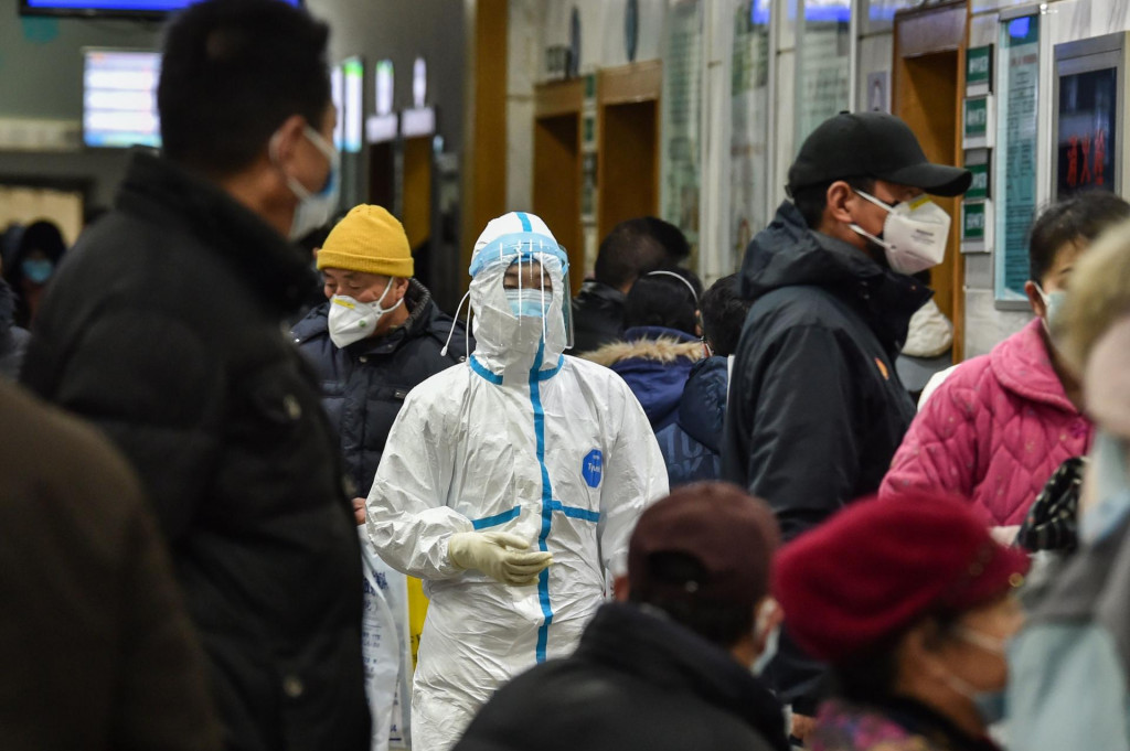 A medical staff member (C) wearing protective clothing to help stop the spread of a deadly virus which began in the city, walks at the Wuhan Red Cross Hospital in Wuhan on January 24, 2020. - Chinese authorities rapidly expanded a mammoth quarantine effort aimed at containing a deadly contagion on January 24 to 13 cities and a staggering 41 million people, as nervous residents were checked for fevers and the death toll climbed to 26. (Photo by Hector RETAMAL/AFP)