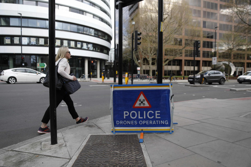 A picture shows a sign warning of police drones in operation in central London on April 6, 2020, as life in Britain continues during the nationwide lockdown to combat the novel coronavirus pandemic. - British Prime Minister Boris Johnson was in St Thomas&amp;#39; hospital on Monday undergoing tests after suffering ”persistent” symptoms of coronavirus for 10 days, but colleagues insisted he remains in charge of the government. (Photo by Tolga AKMEN/AFP)