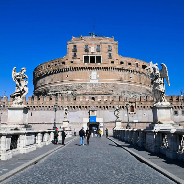 People walk across Sant&amp;#39;Angelo bridge leading to the closed Sant&amp;#39;Angelo Castle in Rome on March 11, 2020 a day after Italy imposed unprecedented national restrictions on its 60 million people Tuesday to control the deadly COVID-19 coronavirus. (Photo by ANDREAS SOLARO/AFP)