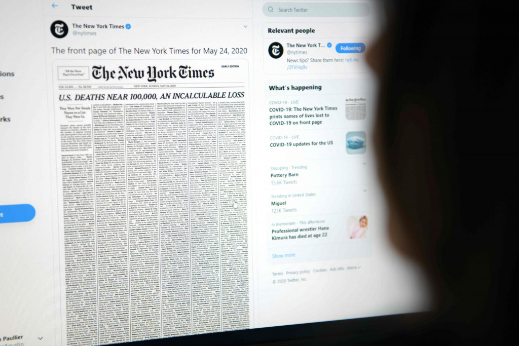This picture taken on May 23, 2020, in Los Angeles, California, shows a woman looking at a computer screen with a tweet by the New York Times newspaper account showing the early edition front page of May 24, 2020, with a list of 1,000 names printed on it, that represents 1% of the lives lost due to the novel coronavirus pandemic, COVID-19, in the US. (Photo by Agustin PAULLIER/AFP)