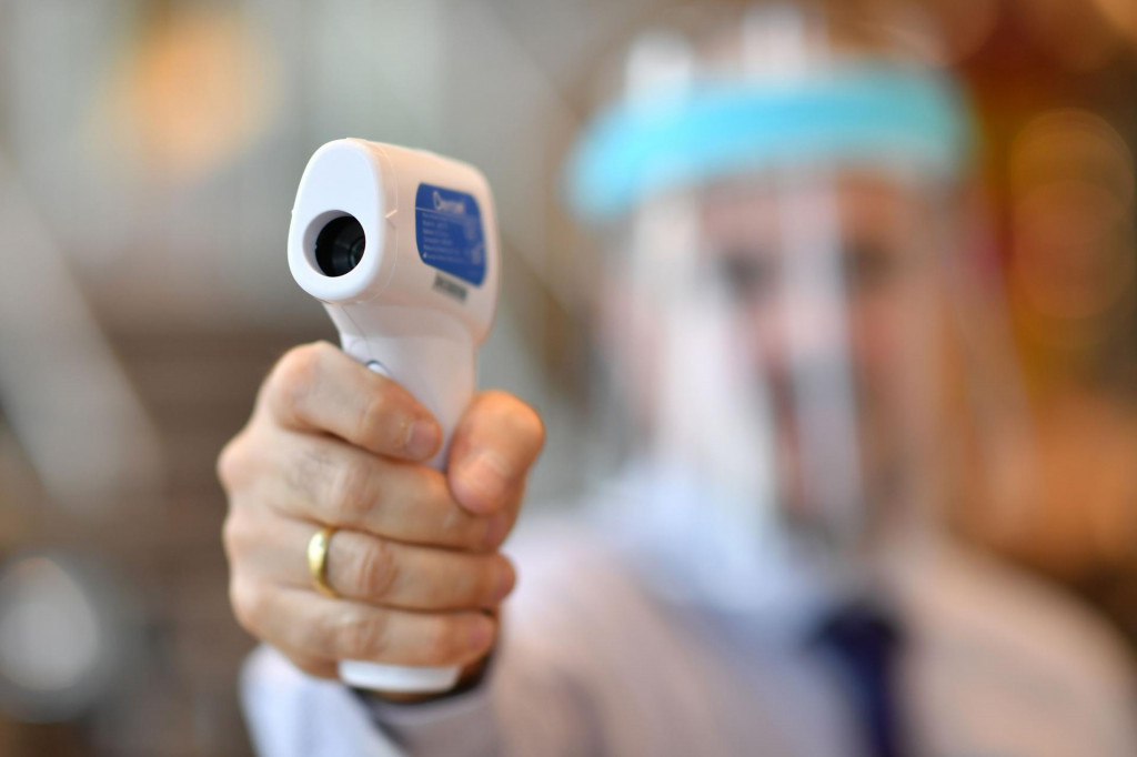 A member of staff wearing a face shield uses a laser thermometer to test customer&amp;#39;s temperatures in a Furniture Village store in Croydon, in south-east London on June 5, 2020, following the easing of the lockdown restrictions during the novel coronavirus COVID-19 pandemic. - UK retail sales dived by a record 18.1 percent in April with the country in coronavirus lockdown. Most shops will soon be allowed to reopen, as Britain -- with the world&amp;#39;s second-highest death toll in the coronavirus outbreak -- took its biggest step out of lockdown this week. (Photo by BEN STANSALL/AFP)