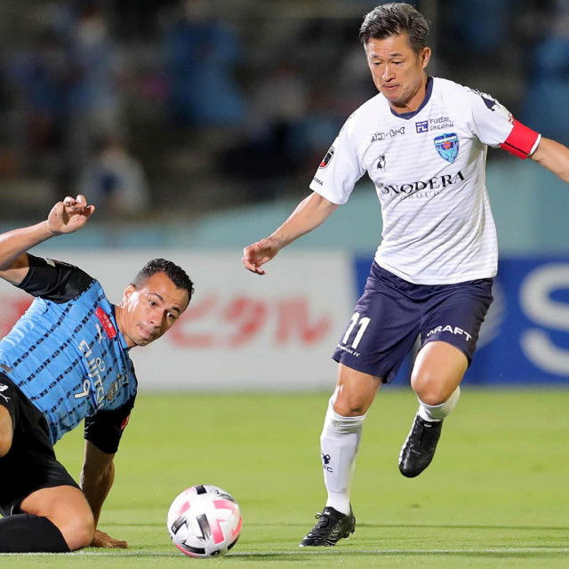 Yokohama FC forward Kazuyoshi Miura (R) is tackled by Kawasaki Frontale forward Leandro Damiao during the J-League football match between Kawasaki Frontale and Yokohama FC at Todoroki Athletics stadium in Kawasaki on September 23, 2020. - Miura was in the starting line-up for Yokohama FC&amp;#39;s clash against Kawasaki Frontale, and at 53 years, six months and 28 days old easily smashed the record for oldest-ever J-League first division starter set by Masashi Nakayama in 2012. (Photo by STR/JIJI PRESS/AFP)/Japan OUT