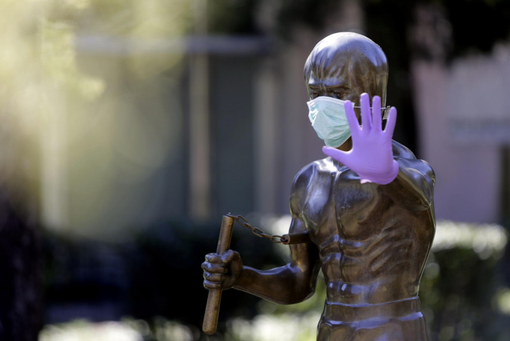 A picture taken on April 2, 2020 shows the statue dedicated to martial arts icon and actor Bruce Lee, wearing surgical gloves and a face mask, in the central park of Mostar as Bosnia Herzegovina records 518 people infected by the COVID-19, the novel coronavirus. - The statue was made by Croatian sculptor Ivan Fijolic and was erected in Mostar&amp;#39;s central park, on 2005. (Photo by STR/AFP)/RESTRICTED TO EDITORIAL USE - MANDATORY MENTION OF THE ARTIST UPON PUBLICATION - TO ILLUSTRATE THE EVENT AS SPECIFIED IN THE CAPTION