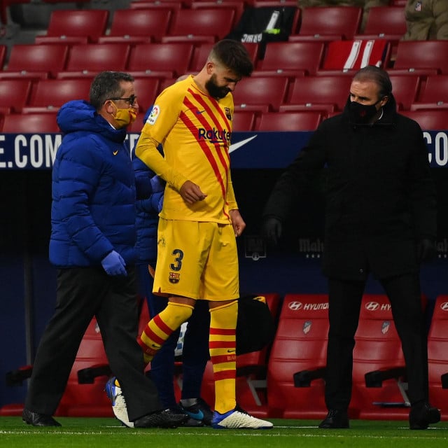 Barcelona&amp;#39;s Spanish defender Gerard Pique (C) walks off the pitch after getting injured during the Spanish League football match between Club Atletico de Madrid and FC Barcelona at the Wanda Metropolitano stadium in Madrid on November 21, 2020. (Photo by GABRIEL BOUYS/AFP)