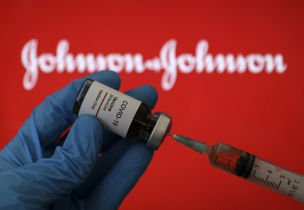 ANKARA, TURKEY - DECEMBER 24: In this photo illustration taken in Ankara, Turkey on December 24, 2020 Johnson &amp; Johnson COVID-19 vaccine logo is displayed on a screen with a syringe and ampoule in the front. Hakan Nural/Anadolu Agency (Photo by Hakan Nural/ANADOLU AGENCY/Anadolu Agency via AFP)