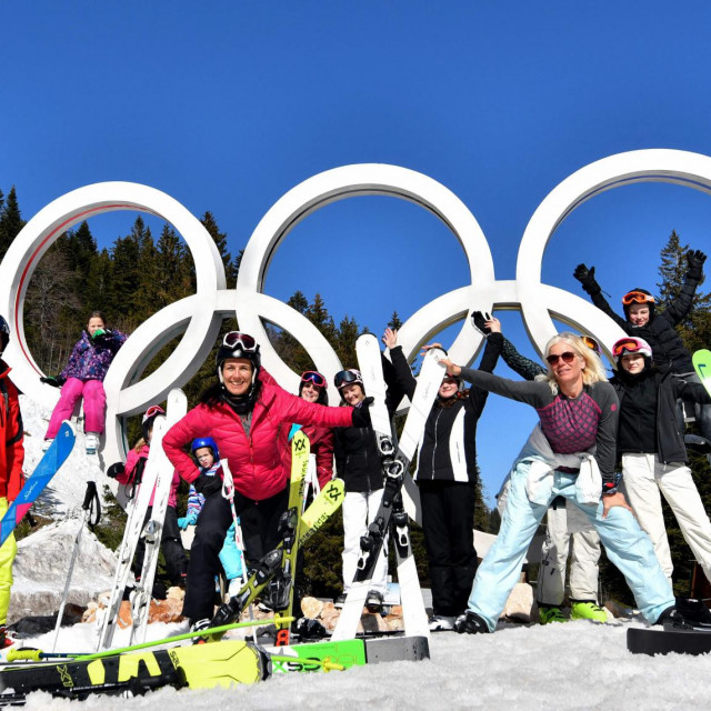 Skiers pose in front of the Olympic Rings on the slopes of Mount Jahorina near the Bosnian capital of Sarajevo, on February 26, 2021. - Although some disease prevention measures have implemented, most transport systems are functional and many accommodation option are available. Jahorina Olympic centre is recording a high numbers of visitors in the winter 2020/21 season. Domestic visitors as well as from neighbouring countries, where ski centres have been closed for most of the season in order to prevent spread of the new coronavirus(Covid-19). (Photo by ELVIS BARUKCIC/AFP)