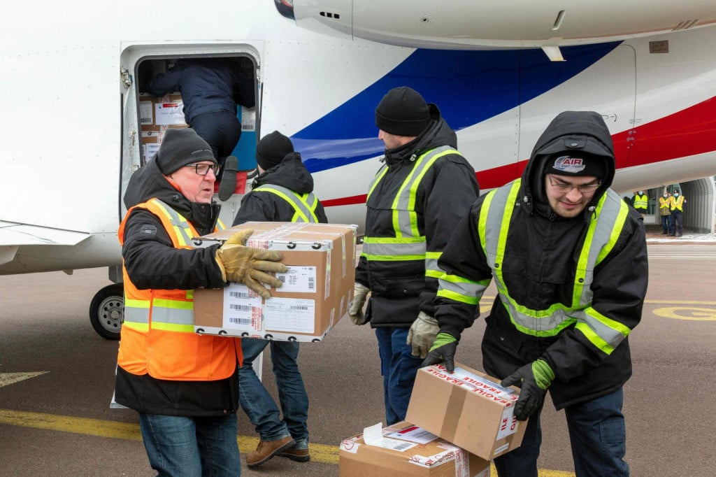Workers unload boxes of Moderna Covid-19 vaccines from a Falcon aircraft, in Saint-Pierre, in the French northern Atlantic archipelago of Saint-Pierre-et-Miquelon, on March 20, 2021. - French Seas Minister arrived to Saint-Pierre and Miquelon to deliver 9,600 doses of Moderna Covid-19 vaccines with a Falcon military flight, ahead of a Covid-19 vaccination campaign in the territory. (Photo by Chantal Briand/AFP)