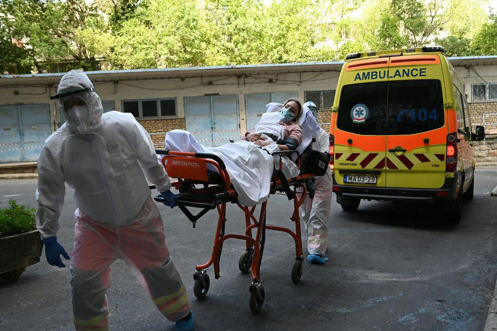 Participants of an exercise wear protective suits as they transport a presumed patient to the Kutvolgyi hospital in Budapest, Hungary, on August 27, 2020, during a training for medical staff, police and military officials, where the arrival of a tourist bus with coronavirus-infected travellers was simulated. (Photo by ATTILA KISBENEDEK/AFP)