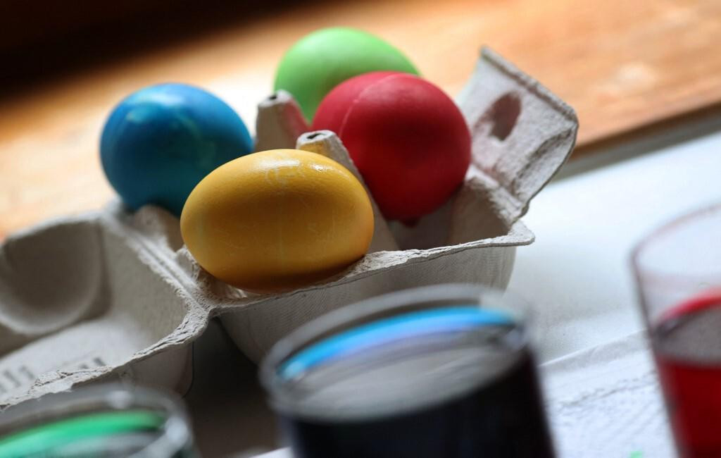 14 March 2021, Bavaria, Kempten: Colored hard boiled eggs lie behind jars of Easter egg paint. Photo: Karl-Josef Hildenbrand/dpa (Photo by KARL-JOSEF HILDENBRAND/DPA/dpa Picture-Alliance via AFP)