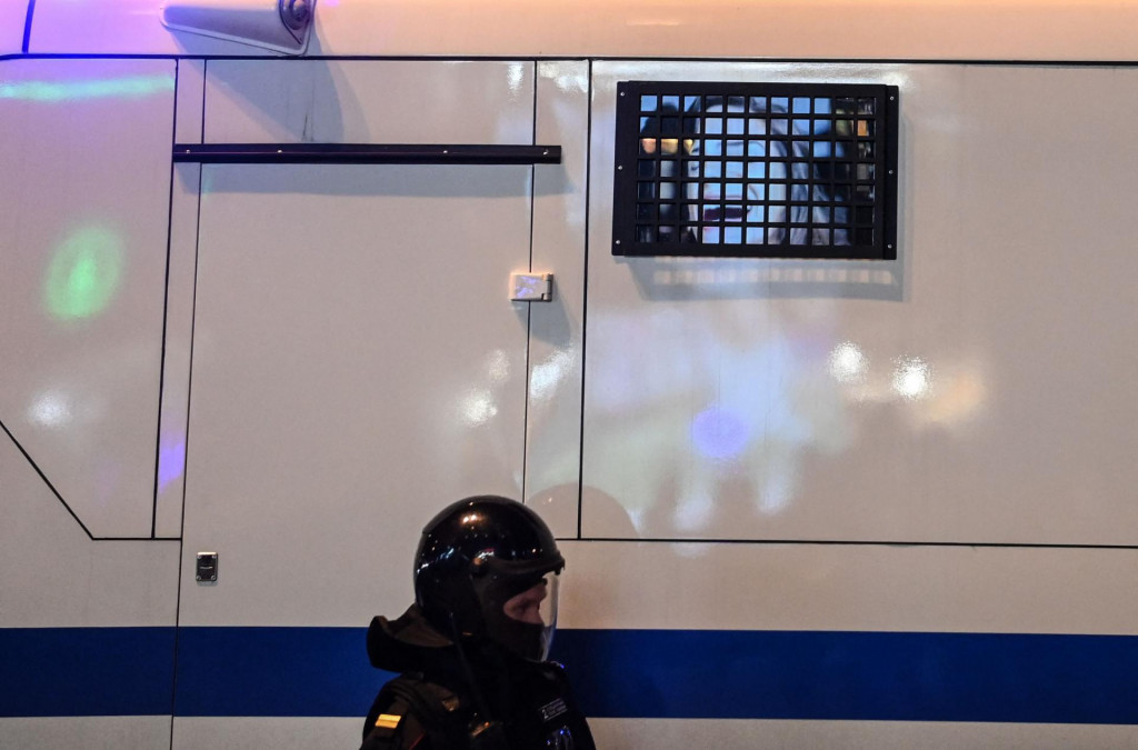 A Russian riot police officer patrols near a police bus with an advertising photo reflecting on a window during a rally in support of jailed Kremlin critic Alexei Navalny, in Moscow on April 21, 2021. - Jailed Kremlin critic Alexei Navalny&amp;#39;s team called for demonstrations in more than 100 cities, after the opposition figure&amp;#39;s doctors said his health was failing following three weeks on hunger strike. (Photo by Kirill KUDRYAVTSEV/AFP)
