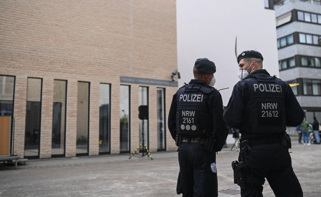 Policemen stand in front of the synagogue during a vigil of the Initiative against Anti-Semitism Gelsenkirchen in Gelsenkirchen, western Germany, on May 14, 2021. - Germany vowed ”unwavering” protection of its synagogues after scattered demonstrations over the escalating conflict in the Middle East saw protesters shout anti-Israeli slogans and burn Israeli flags, and around 180 people shouted anti-Israeli slogans at a march in Gelsenkirchen in the evening of May 12, 2021. (Photo by Ina FASSBENDER/AFP)