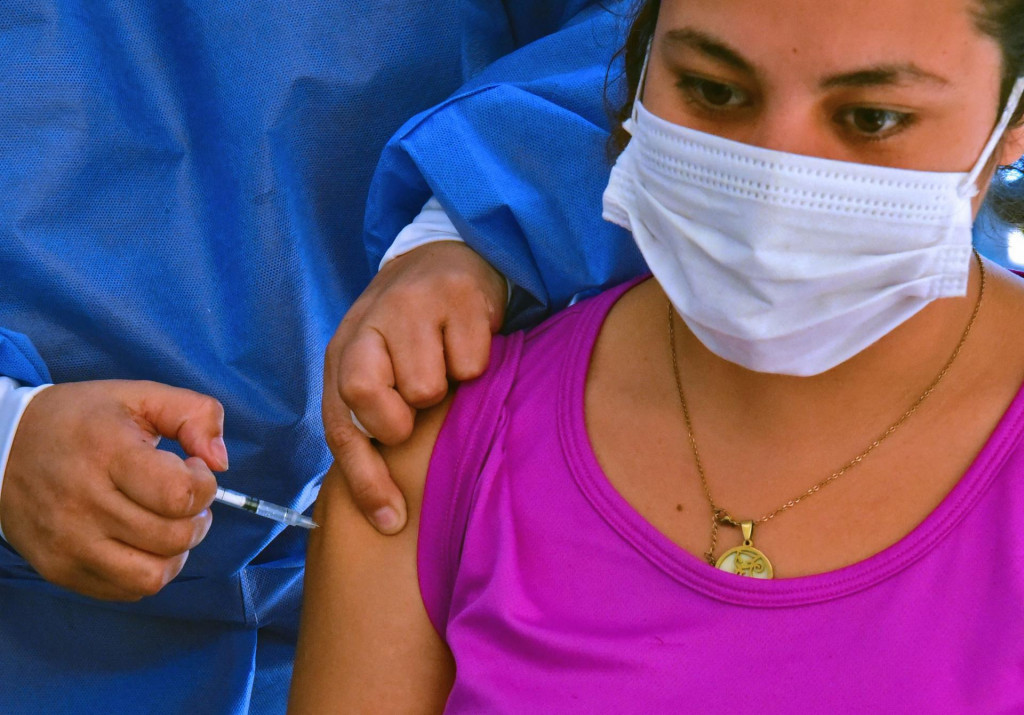 A pregnant woman receives a dose of the Moderna vaccine against COVID-19 at the Maternity and Children&amp;#39;s Hospital of the Trinidad neihghborhood in Asuncion, on June 11, 2021. (Photo by NORBERTO DUARTE/AFP)