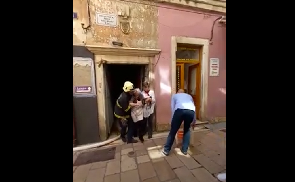 Vatrogasac pomaže starici da izađe iz požarom zahvaćene zgrade