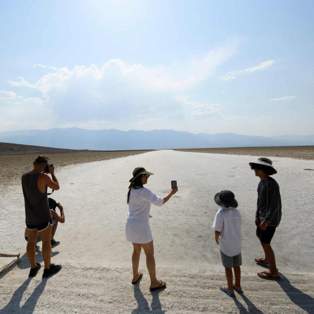Visitors take pictures at the salt flats of Badwater Basin inside Death Valley National Park on June 17, 2021 in Inyo County, California. - Much of the western United States is braced for record heat waves this week, with approximately 50 million Americans placed on alert on June 15 for &rdquo;excessive&rdquo; temperatures, which could approach 120 degrees Fahrenheit (50 degrees Celsius) in some areas. The National Park Service warns of extreme summer heat, urging tourists to carry extra water and &rdquo;travel prepared to survive&rdquo; in the hottest, lowest, and driest national park featuring steady drought and extreme climates. (Photo by Patrick T. FALLON/AFP)
