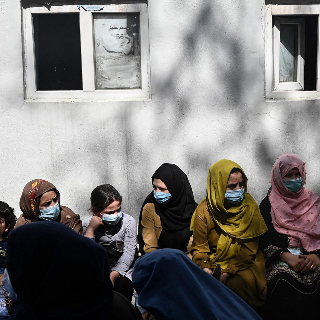 People sit in a queue to submit their passport applications at an office in Kabul on July 25, 2021. - Dozens begin lining up at the passport office in Kabul before dawn most days, and by eight in the morning the queue already stretches for a good hundred metres. (Photo by SAJJAD HUSSAIN/AFP)/TO GO WITH Afghanistan-conflict-passport,FOCUS by Aymeric VINCENOT
