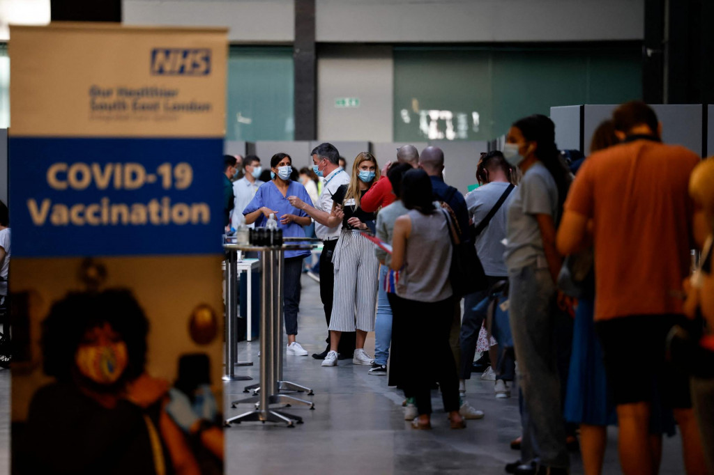 Members of the public queue to receive the Pfizer-BioNTech Covid-19 vaccine in the Turbine Hall at a temporary Covid-19 vaccine centre at the Tate Modern in central London on July 16, 2021. (Photo by Tolga Akmen/AFP)