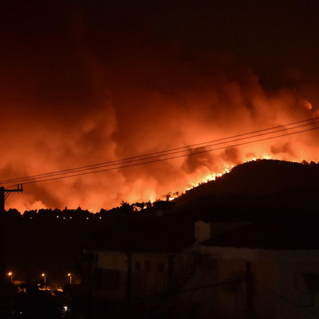 This picture taken on August 5, 2021 shows flames rising from a fire spreading around Kapandriti, on the outskirts of Athens. - Firefighters were battling a series of raging blazes in sweltering heat on August 5, 2021, in western and eastern Greece, and near Athens where a fire that had been coming under control regained strength. (Photo by Louisa GOULIAMAKI/AFP)