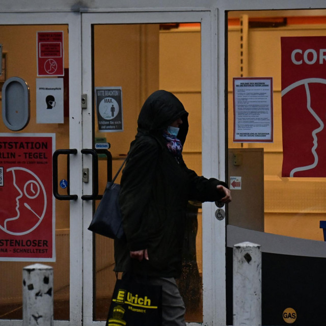 A pedestrian walks past a Covid test centre in Berlin on November 4, 2021. - Germany on November 4, 2021 saw its biggest daily rise in Covid-19 cases since the pandemic began, figures from the Robert Koch Institute (RKI) health agency showed. The country recorded 33,949 new cases in the past 24 hours, the RKI said, beating the previous daily record of 33,777 on December 18, 2020. (Photo by Tobias SCHWARZ/AFP)