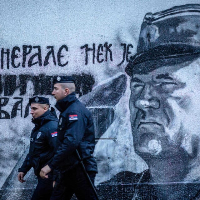 Policajci prolaze pored murala koji prikazuje Ratka Mladića u Beogradu