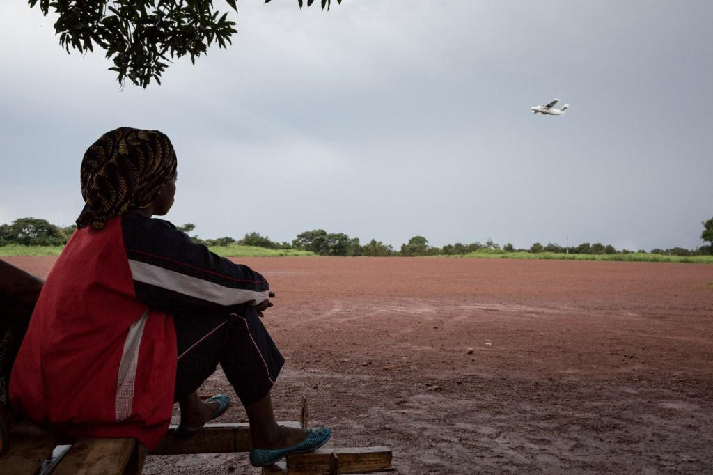 A young Central African woman watches a plane taking off on August 23, 2017 at Bangassou airport, south-eastern Central African Republic. (Photo by ALEXIS HUGUET/AFP)