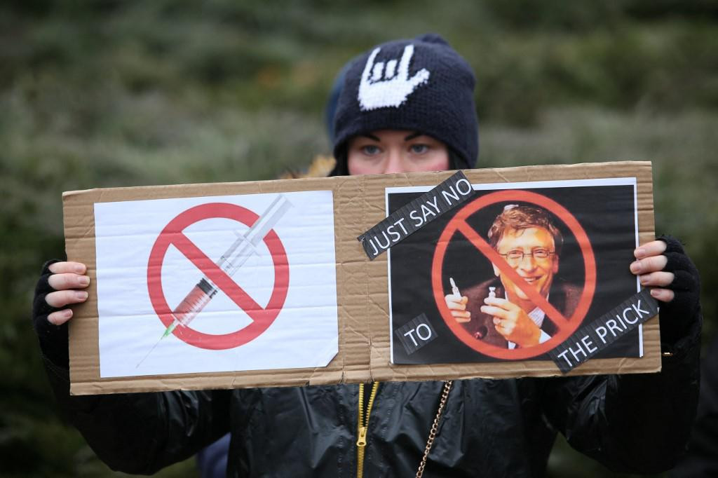 Žena u Ukrajini drži plakat s fotografijama cjepiva i Billa Gatesa, kojeg urotnici sumnjiče za čipiranje, s natpisom &amp;#39;Samo reci ne kretenu&amp;#39;