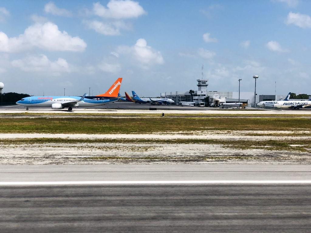 Zrakoplov kanadskog Sunwing Airlinesa (s narančastim repom) na pisti zračne luke u Cancunu