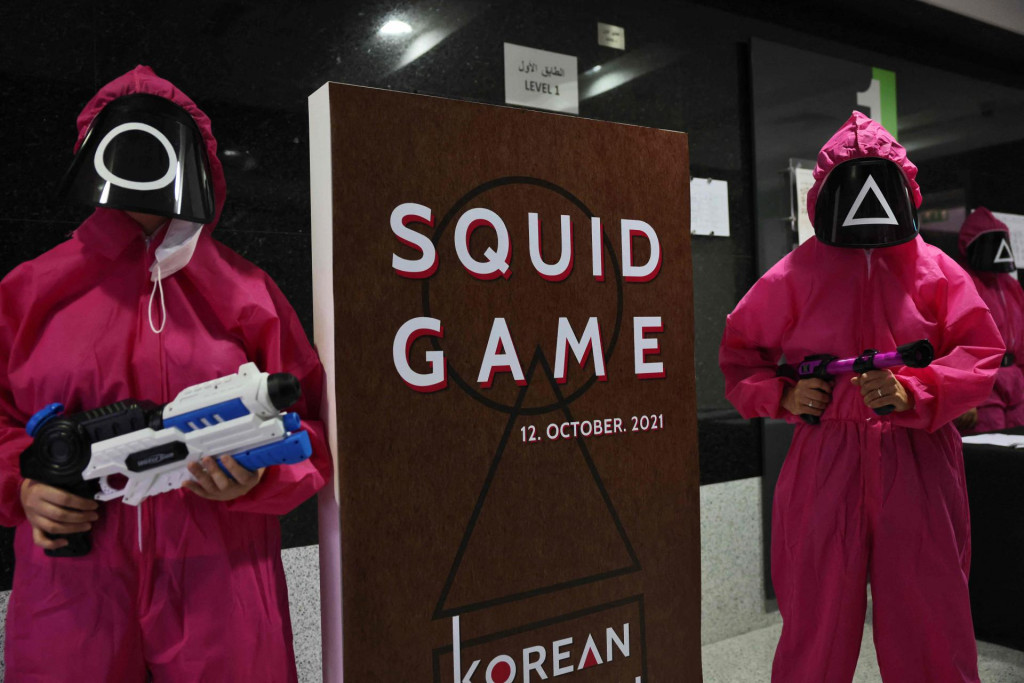 Participants take part in an event where they play the games of Netflix smash hit ”Squid Game” at the Korean Cultural Centre in Abu Dhabi, on October 12, 2021. - A dystopian vision of a polarised society, ”Squid Game” blends a tight plot, social allegory and uncompromising violence to create the latest South Korean cultural phenomenon to go global. (Photo by Giuseppe CACACE/AFP)