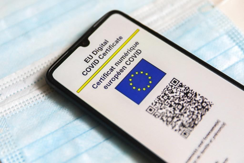 EU Digital COVID Certificate is displayed on a mobile phone screen photographed on surgical masks background for illustration photo during the spread of the fifth wave of the coronavirus pandemic. Gliwice, Poland on January 23, 2022. (Photo by Beata Zawrzel/NurPhoto) (Photo by Beata Zawrzel/NurPhoto/NurPhoto via AFP)