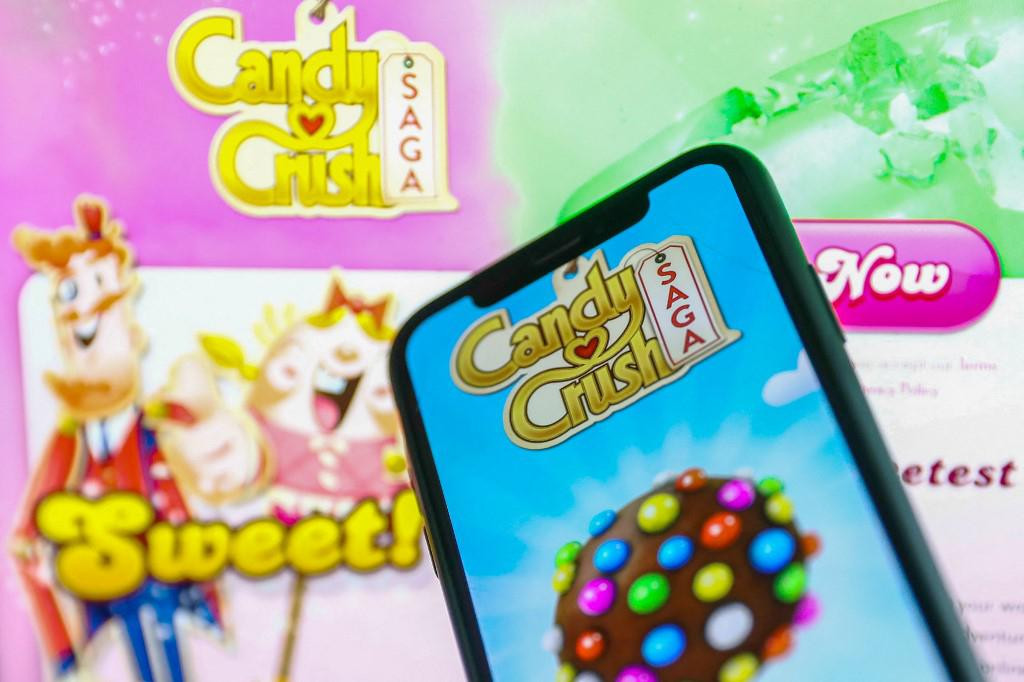 Candy Crush Saga logo displayed on a phone screen and Candy Crush website displayed in the background is seen in this illustration photo taken in Krakow, Poland on January 23, 2022. (Photo by Jakub Porzycki/NurPhoto) (Photo by Jakub Porzycki/NurPhoto/NurPhoto via AFP)