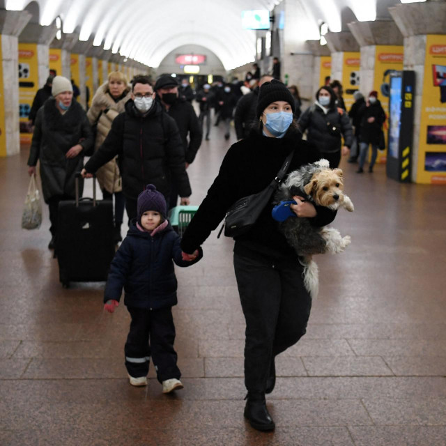 Žena s djetetom i psom u stanici metroa