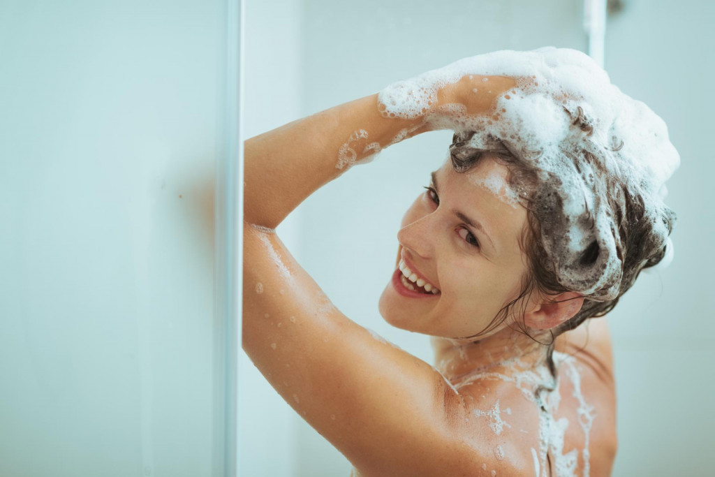 &lt;p&gt;Smiling young woman washing head with shampoo&lt;/p&gt;
