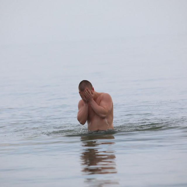 &lt;p&gt;Muškarac pliva u Azovskom moru u ukrajinskoj industrijskoj luci Mariupolj (23. veljače 2022.)&lt;/p&gt;