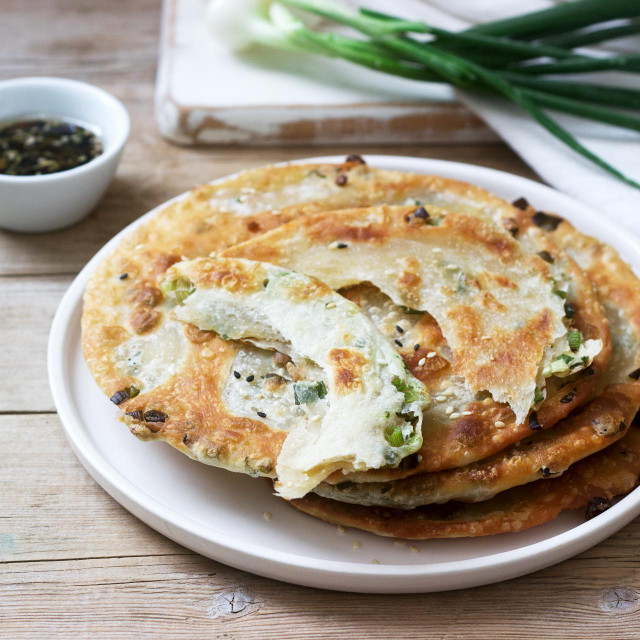 &lt;p&gt;Homemade appetizing scallion pancakes and a bunch of green onions. Rustic style, selective focus.&lt;/p&gt;