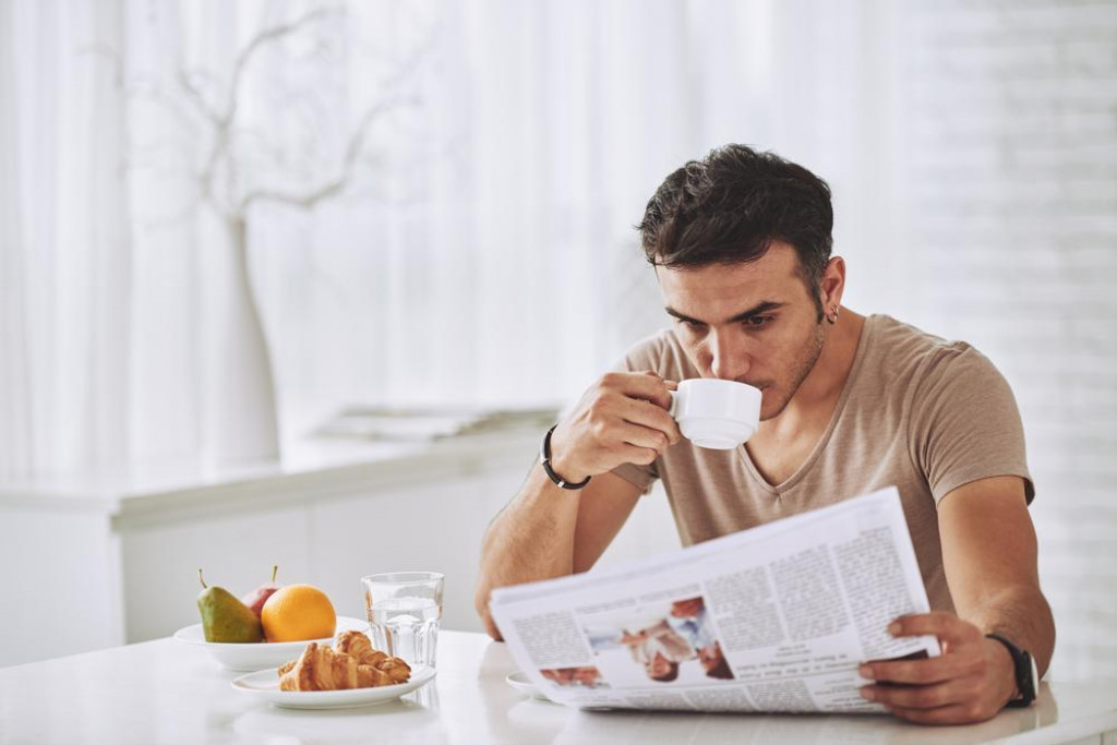 &lt;p&gt;Young man drinking coffee and reading newspaper at home&lt;/p&gt;