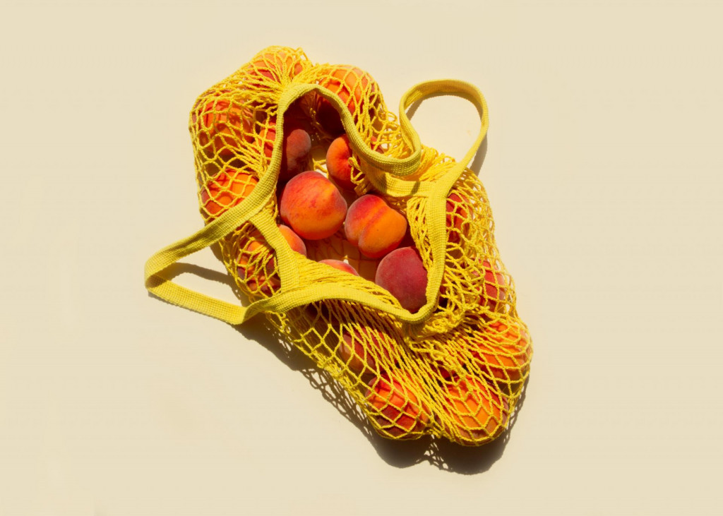 &lt;p&gt;Ripe peaches in a mesh bag or string bag on light yellow background. Flat lay. Zero waste. Top view.&lt;/p&gt;
