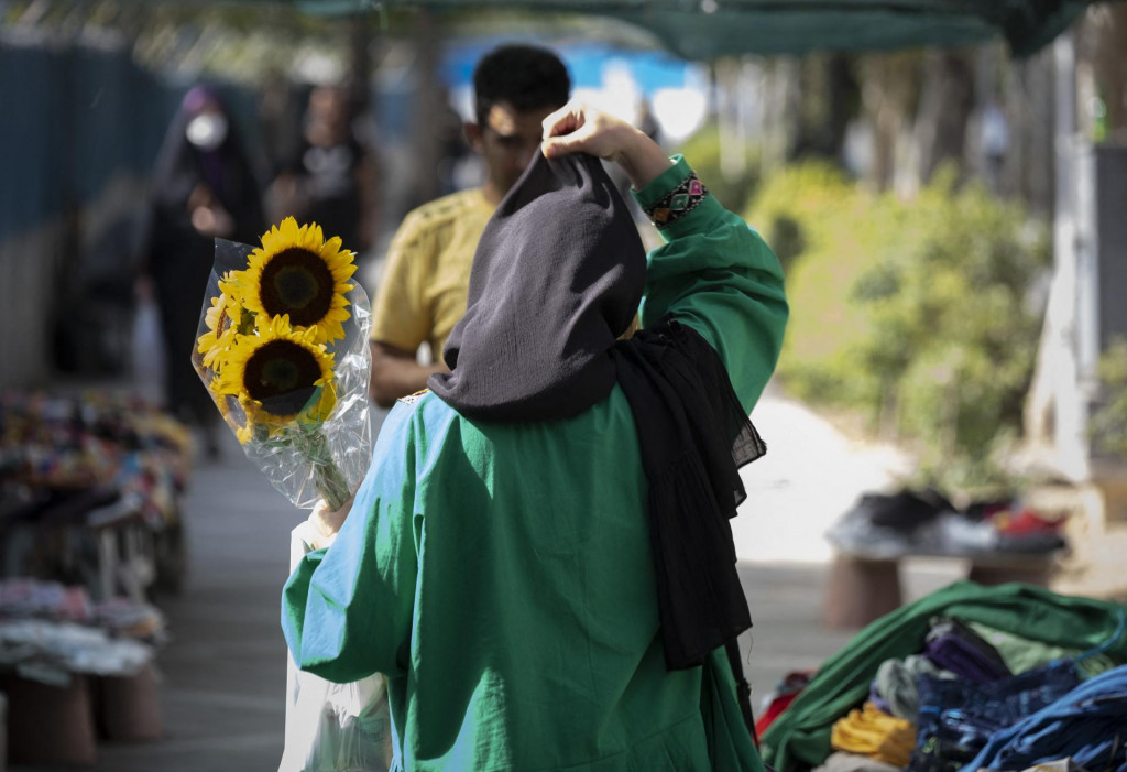 &lt;p&gt;An Iranian woman adjusts her scarf while carrying sunflowers in northern Tehran on July 9, 2022. Iranian President Ebrahim Raisi called in a meeting with officials on Wednesday, lack of compliance with hijab rules promotion of corruption in an Islamic country such as Iran. (Photo by Morteza Nikoubazl/NurPhoto) (Photo by Morteza Nikoubazl/NurPhoto/NurPhoto via AFP)&lt;/p&gt;