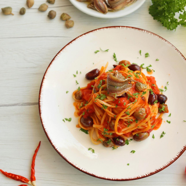 &lt;p&gt;Talijanski ‘Spaghetti alla Puttanesca‘ rade se s umakom od rajčica, inćunima, maslinama, kaparima, parmezanom i malo ljute crvene paprike&lt;/p&gt;