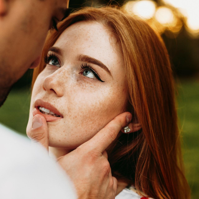 &lt;p&gt;Portrait of a red haired woman with freckles and green eyes looking at her boyfriend while he is touching her lips with a finger against sunset while dating&lt;/p&gt;