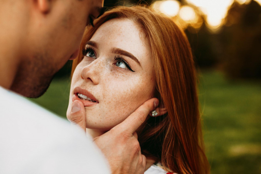 &lt;p&gt;Portrait of a red haired woman with freckles and green eyes looking at her boyfriend while he is touching her lips with a finger against sunset while dating&lt;/p&gt;