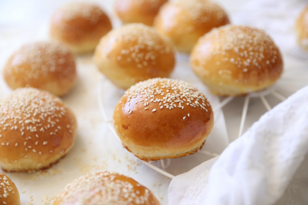 &lt;p&gt;Homemade freshly baked plain golden brown soft hamburger buns topped with sesame seeds against white background. copy space flat lay, top view. Homebaking, freshness, bbq concept&lt;/p&gt;