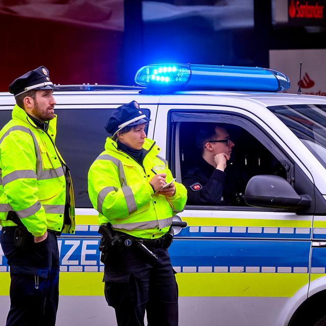 &lt;p&gt;Hannover, Germany, March 8., 2020Female policewoman and her male colleague in yellow high-visibility vests in front of a police car with blue light switched on&lt;/p&gt;