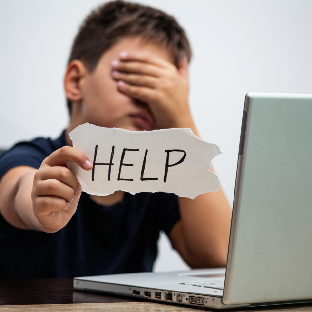 &lt;p&gt;Sad and scared young boy with computer laptop suffering cyberbullying and harassment being online abused by stalker or gossip feeling desperate and humiliated in cyber bullying concept.&lt;/p&gt;
