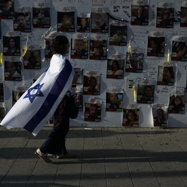 &lt;p&gt;Žena s izraelskom zastavom pred slikama otetih u Tel Avivu&lt;/p&gt;