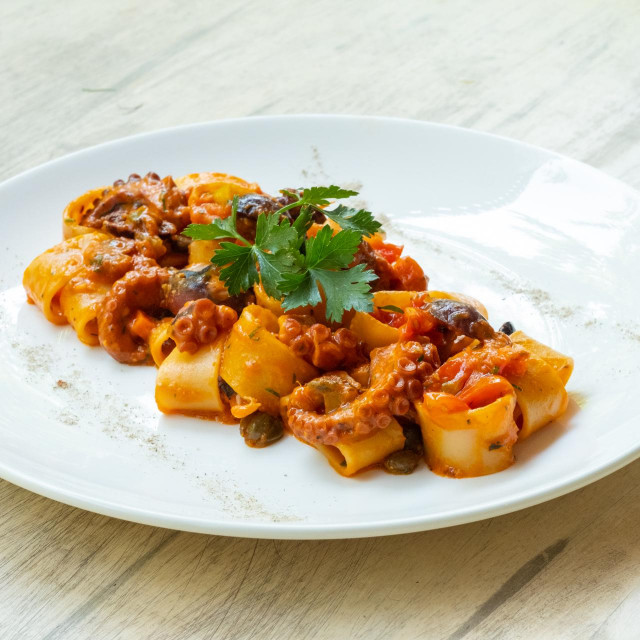 &lt;p&gt;close up of calamarata octopus italian traditional sicilian pasta homemade seafood sauce with tomato,basil,parsley,herbs,chilly prepared by professional chef in a fine dining restaurant&lt;/p&gt;