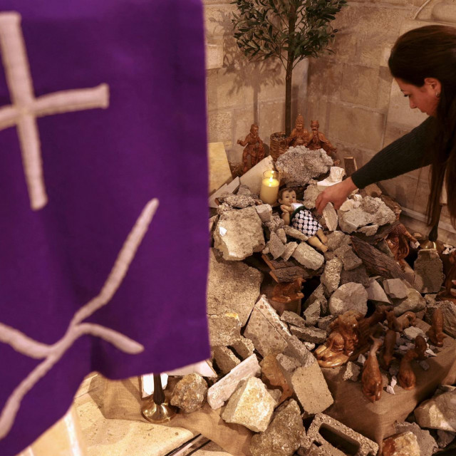 &lt;p&gt;Žena u Betlehemu izrađuje instalaciju scene Kristova rođenja s likom koji ”simbolizira malog Isusa koji leži u jaslicama usred ruševina”&lt;/p&gt;