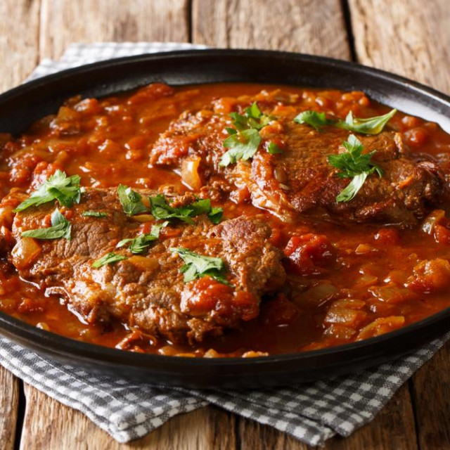 &lt;p&gt;smothered beef steak cooked in tomato sauce with vegetables close-up on the table. Horizontal&lt;/p&gt;